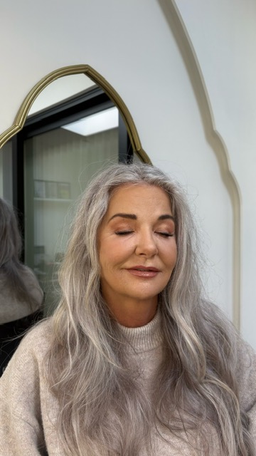 Klant bij de spiegel na haar behandeling